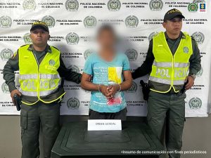 En la imagen se ve una persona detenida entre dos uniformados de la Policía