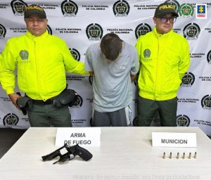 En la fotografía aparece el capturado junto a dos agentes de la Policía Nacional. En la parte superior se observa un banner de la Policía Nacional 