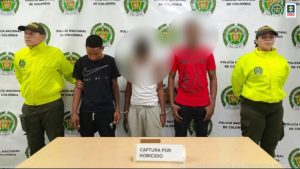 En la fotografía aparece el capturado, con camiseta negra, junto a dos agentes de la Policía Nacional. En la parte superior está un banner de la Policía Nacional