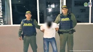 El capturado está esposado y custodiadospor uniformados de la Policía Nacional.