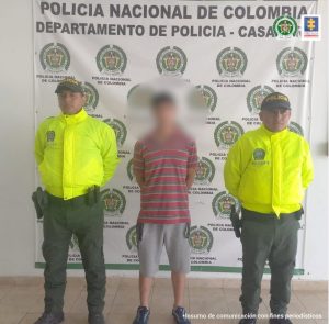 los cuatro capturados están esposados y custodiados por uniformados de la Policía Nacional.