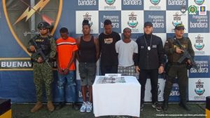 En la fotografía están los cuatro capturados junto a un servidor del CTI. En la parte posterior aparece una mesa con dinero