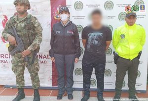 En la fotografía aparece el capturado junto con una servidora del CTI, un agente de la Policía y un soldado del Ejército. En la parte superior están un banner de la Policía Nacional 