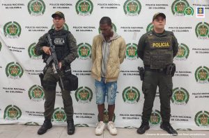 En la fotografía aparece el capturado junto a dos agentes de la Policía Nacional. En la parte superior está un banner de la Policía Nacional