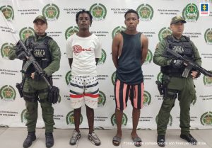 En la fotografía aparecen los dos capturados junto a dos agentes del Gaula de la Policía Nacional. En la parte superior está un banner de la Policía Nacional