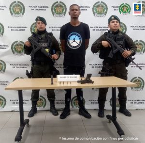 En la fotografía aparece el capturado junto a dos agentes del Goes de la Policía Nacional. En la parte superior está un banner de la Policía Nacional