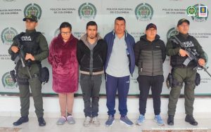 En la fotografía aparecen los tres capturados junto a un servidor del CTI, un agente del Goes de la Policía Nacional y un soldado del Ejército. En la parte superior está un banner del Ejército Nacional, un banner de la Fiscalía General y un banner de la Policía Nacional