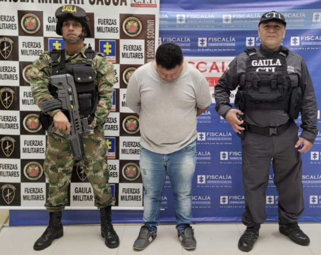 En la fotografía aparece el capturado junto a un servidor del CTI y un soldado del Gaula Militar. En la parte superior está un banner del Gaula Militar y otro banner de la Fiscalía General de la Nación