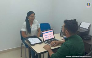 En la fotografía se ve la oficina del Punto de Atención de Fiscalía PAF con un funcionario y una ciudadana siendo atendida. 