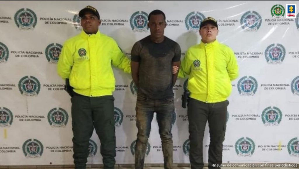 En la fotografía aparece el capturad junto a dos agentes de la Policía Nacional. En la parte superior está un banner de la Policía Nacional 