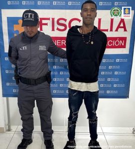 En la fotografía aparece el capturado junto a un servidor del CTI. En la superior está un banner de la Fiscalía General de la Nación  