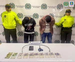 En la fotografía aparecen los capturados junto a un servidor del CTI y tres agentes de la Policía Nacional. En la parte posterior está una mesa con una tijera, un cable metálico y dinero en efectivo.