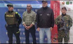 En la fotografía aparece el capturado junto a un servidor del CTI, un agente de la Policía Nacional y un soldado del Ejército Nacional.  En la parte superior está un banner de la Fiscalía General y otro banner del Ejército 