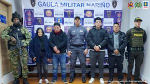 En la fotografía parecen los cuatro capturados junto a un servidor del CTI, un agente de la Policía y un soldado del Gaula Militar. En la parte superior está un banner del Gaula Militar.