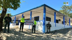 En la imagen se ve a tres uniformados de la Policía Nacional con un cartel en que consta que una casa de campo que está a sus espaldas fue ocupada con fines de extinción por la Fiscalía General de la Nación.