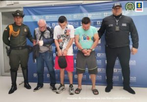 En la fotografía aparecen los tres capturados junto a un servidor del CTI y un agente de Carabineros de la Policía Nacional. En la parte superior está un banner de la Fiscalía General