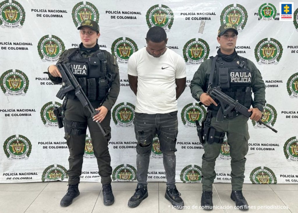 En la fotografía aparece el capturado junto a dos agentes de la Policía Nacional. En la parte superior está un banner de la Policía Nacional