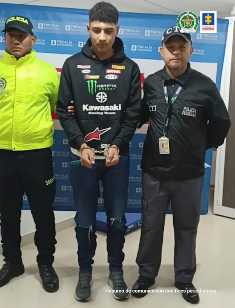En la fotografía aparece el capturado junto a un servidor del CTI y un carabinero de la Policía Nacional. En la parte superior está un banner de la Fiscalía General de la Nación