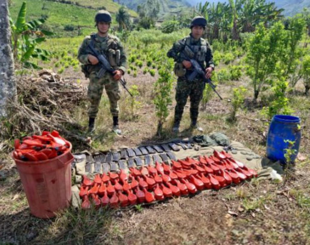 En la fotografía aparece el material explosivo y las partes de armas junto a dos soldados del Ejército Nacional