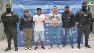 En las fotografías aparecen los dos capturados junto a dos servidores del CTI y a dos agentes del Goes de la Policía Nacional. En la parte superior están dos banner uno de la Fiscalía General y otro banner de la Policía Nacional