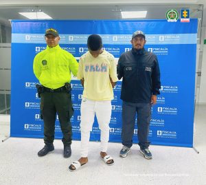 Jaminton Benítez Copete, alias Papigua, acompañado de funcionarios del Cuerpo Técnico de Investigación CTI de la Seccional Chocó y la Policía Nacional. Atrás el pendón de la Fiscalía.