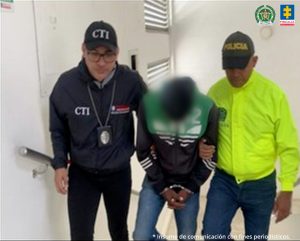 En la imagen se aprecian tres personas entre uniformados de la Policía Nacional y del CTI.