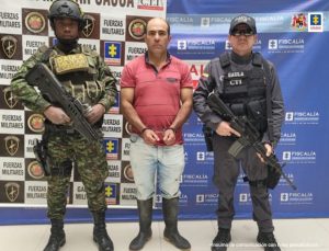 En la fotografía aparece el capturado junto a un servidor del CTI y un soldado del Gaula Militar. En la parte superior está un banner de la Fiscalía General y otro banner del Gaula Militar