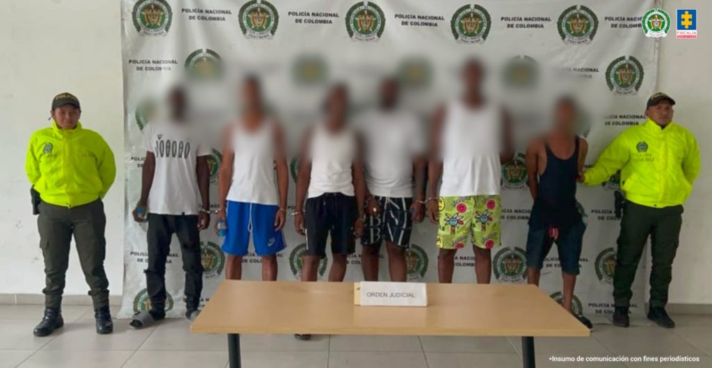 En las fotografía aparecen los seis capturados junto a dos agentes de la Policía Nacional. En la parte superior está un banner de la Policía Nacional