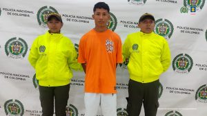 En la imagen aparece una persona de suéter naranja junto entre dos policías.
