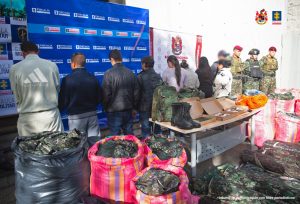 En la fotografía se ve un backing de la Fiscalía, varias personas de espaldas y bolsas con los uniformes del Ejército Nacional.