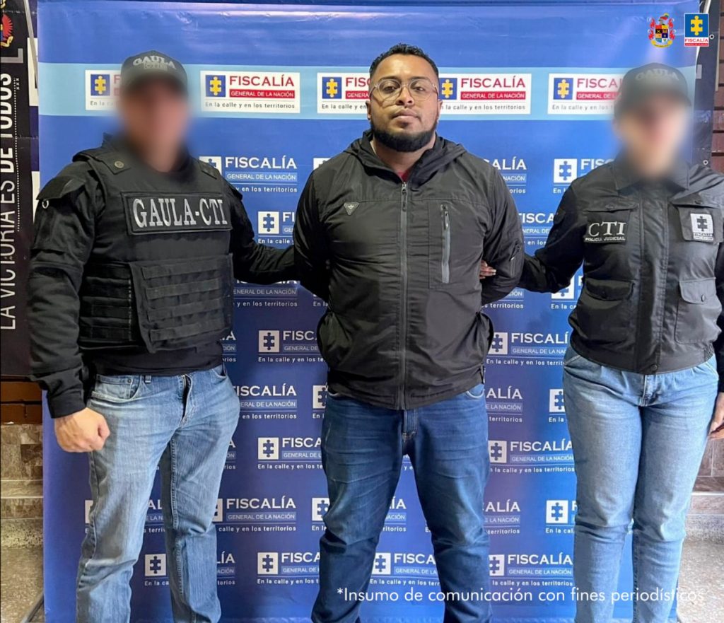 En la imagen se oberva a dos integrantes del CTI y detras un pendón de la Fiscalía.