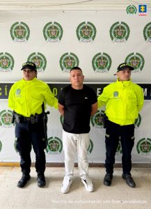 En la imagen aparece el capturado con camiseta negra y en compañía de dos uniformados de la Policía Nacional