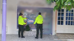 En la imagen aparecen dos uniformados de la Policía Nacional sosteniendo un letrero que indica "bien ocupado"