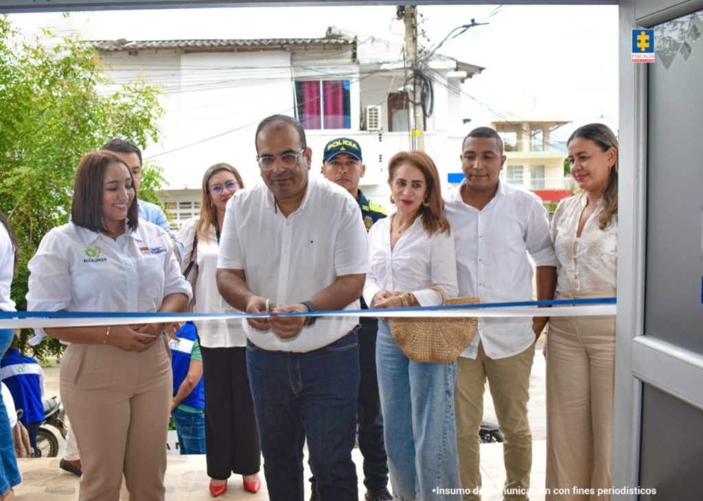 En la imagen aparece una persona cortando una cinta de inauguración, rodeada de ciudadanos y funcionarios.