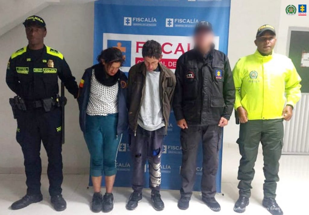En la fotografía aparecen los capturados junto a un servidor del CTI y dos uniformados de la Policía Nacional. En la parte superior está un banner de la Policía