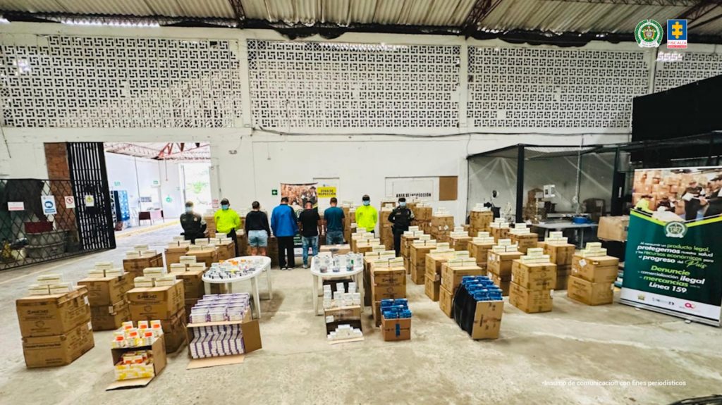 En la imagen se ven cinco personas que fueron capturadas y judicializadas junto a dos uniformados de la Policía Nacional. Además, se observan cajas con 598.429 unidades de medicamentos vencidos, descompuestos o de uso institucional incautados por las autoridades.