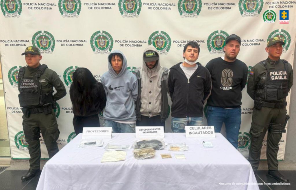 En la imagen aparecen cinco personas capturadas en compañía de uniformados de la Policía Nacional, quienes fueron detenidos en diligencias de registro y allanamiento adelantadas en los barrios Aures y Lisboa en Bogotá.