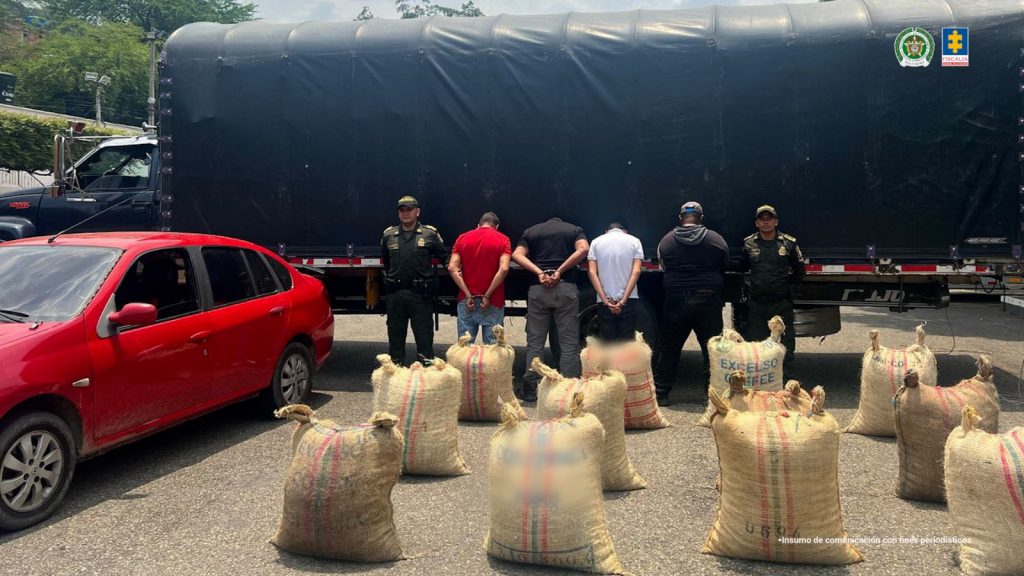Se visualizan a los cuatro capturados de espaldas junto a uniformados de la Policía Nacional. Frente a ellos la carga de cacao recuperada y el automóvil incautado. Detrás de ellos el camión hurtado.