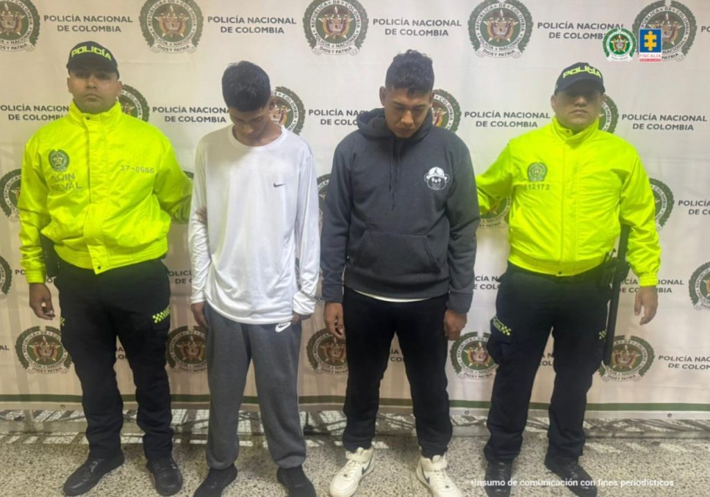 El la fotografía se observan cuatro personas dos de ellas los capturados y dos uniformados de la Policía Nacional.