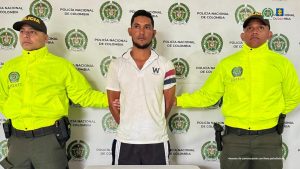 En la fotografía se observan tres personas, dos de ellas uniformados de la Policía Nacional y el capturado.