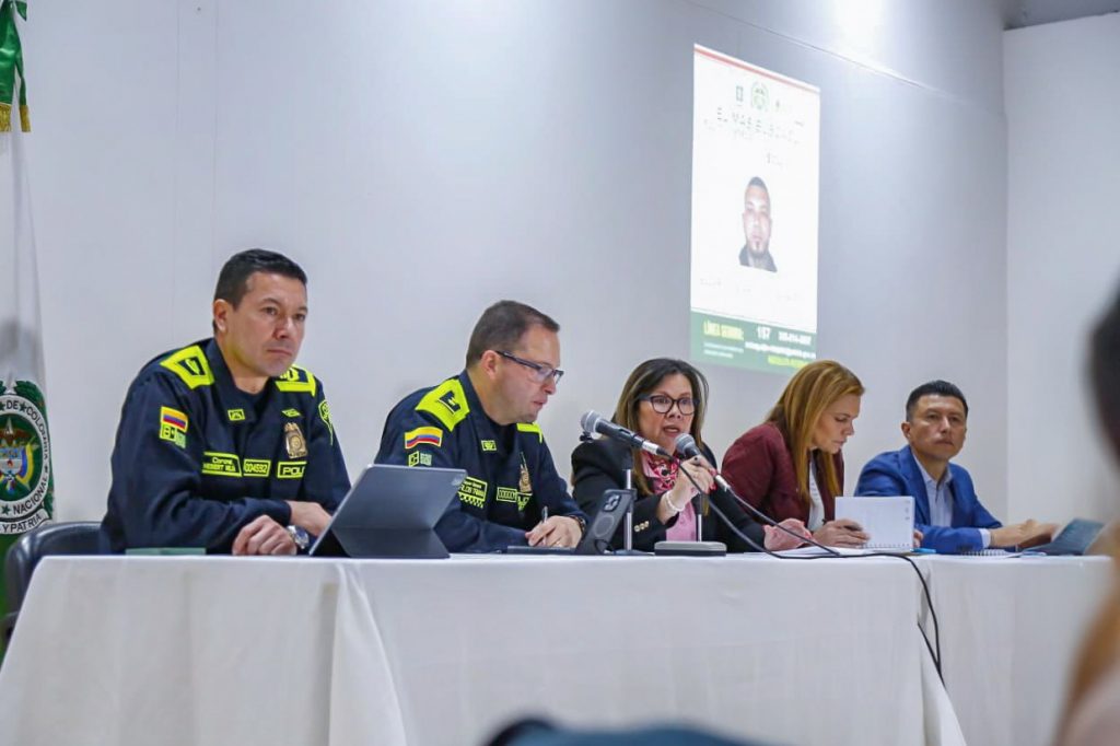 en la fotografia se ven La fiscal general de la Nación, Luz Adriana Camargo Garzón, y el director de la Policía Nacional, mayor general Carlos Fernando Triana Beltrán sentados en frente de una mesa con microfonos dando declaraciones sobre el atentado en contra de Miguel uribe