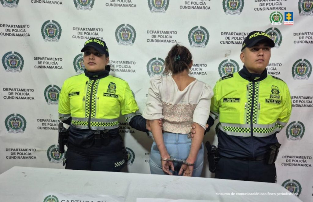 En la imagen aparece la procesada, de espaldas, en medio de una pareja de servidores de la Policía Nacional. 
