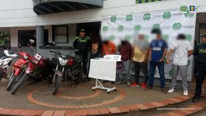  En la imagen aparecen los procesados, en medio de una pareja de servidores de la Policía Nacional. También, se observan los elementos incautados durante el procedimiento de captura. 