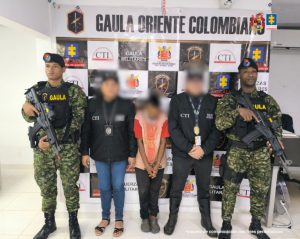 Esta fotografía muestra una captura realizada por las autoridades colombianas. En la imagen se observa a cinco personas posando frente a una lona con los logos de diferentes entidades oficiales, como: GAULA Militares (Grupo de Acción Unificada por la Libertad Personal, unidad especializada en combatir el secuestro y la extorsión). Fiscalía General de la Nación. CTI (Cuerpo Técnico de Investigación). Composición de la imagen: Dos militares del GAULA (uno a la izquierda y otro a la derecha) en uniforme de camuflaje y armados. Dos agentes del CTI en el centro, con rostros desenfocados, usando chaquetas negras identificadas con las siglas "CTI". En el centro se encuentra una persona con las manos esposadas, vestida con ropa informal. Su rostro también está desenfocado, indicando que probablemente es la persona capturada. Un telón institucional con logos de las entidades mencionadas, que se usa comúnmente para registrar operativos exitosos de detención. En la esquina inferior derecha se aclara que la imagen es un "insumo de comunicación con fines periodísticos".