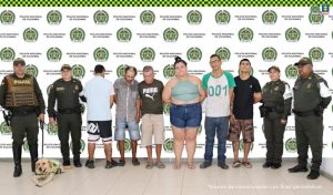 En la imagen aparecen los cinco adultos de frente y el adolescente de espaldas. Todos, en medio de dos parejas de servidores de la Policía Nacional y un canino. 