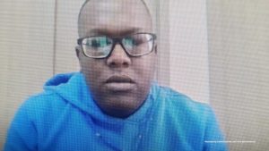 En la foto aparece un hombre usando gafas y una sudadera azul con capucha. La imagen parece ser tomada de una pantalla (posiblemente de una videollamada o transmisión), ya que se notan los píxeles y reflejos en las gafas. El fondo es neutro, con paredes claras.En la parte inferior derecha se observa un texto que dice: “Insumo de comunicación con fines periodísticos”, lo que indica que la imagen fue difundida por una entidad oficial para medios de comunicación.