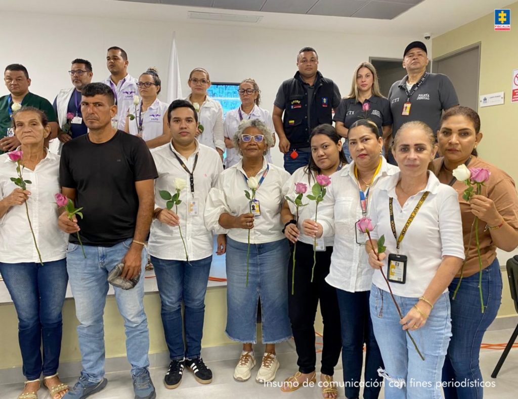 En la imagen se ve un grupo de funcionarios con unas rosas en las manos, en medio de un homenaje a las víctimas de desapariciones forzadas.
