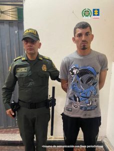 En la imagen se ve a un hombre custodiado por un uniformado de la Policía, quien lo sujeta de un brazo. El hombre es presunto responsable del homicidio de un joven de 18 años en la plaza de mercado de Fusagasugrá (Cundinamarca). 