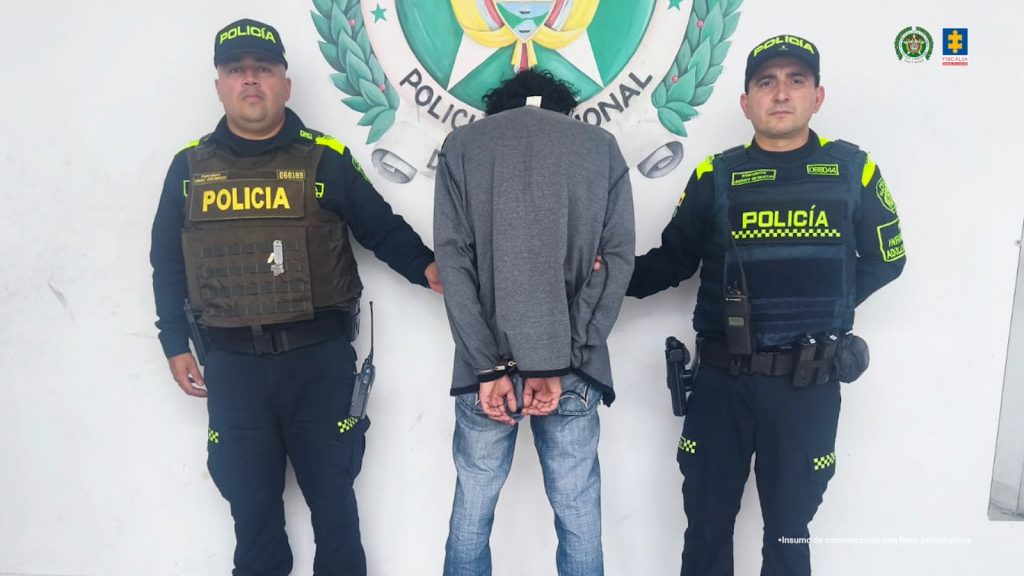 En la fotografía se observan tres personas una de ellas el capturado y dos policías