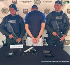 En la imagen se ve a un hombre capturado de espalda junto a dos uniformados del Goes.